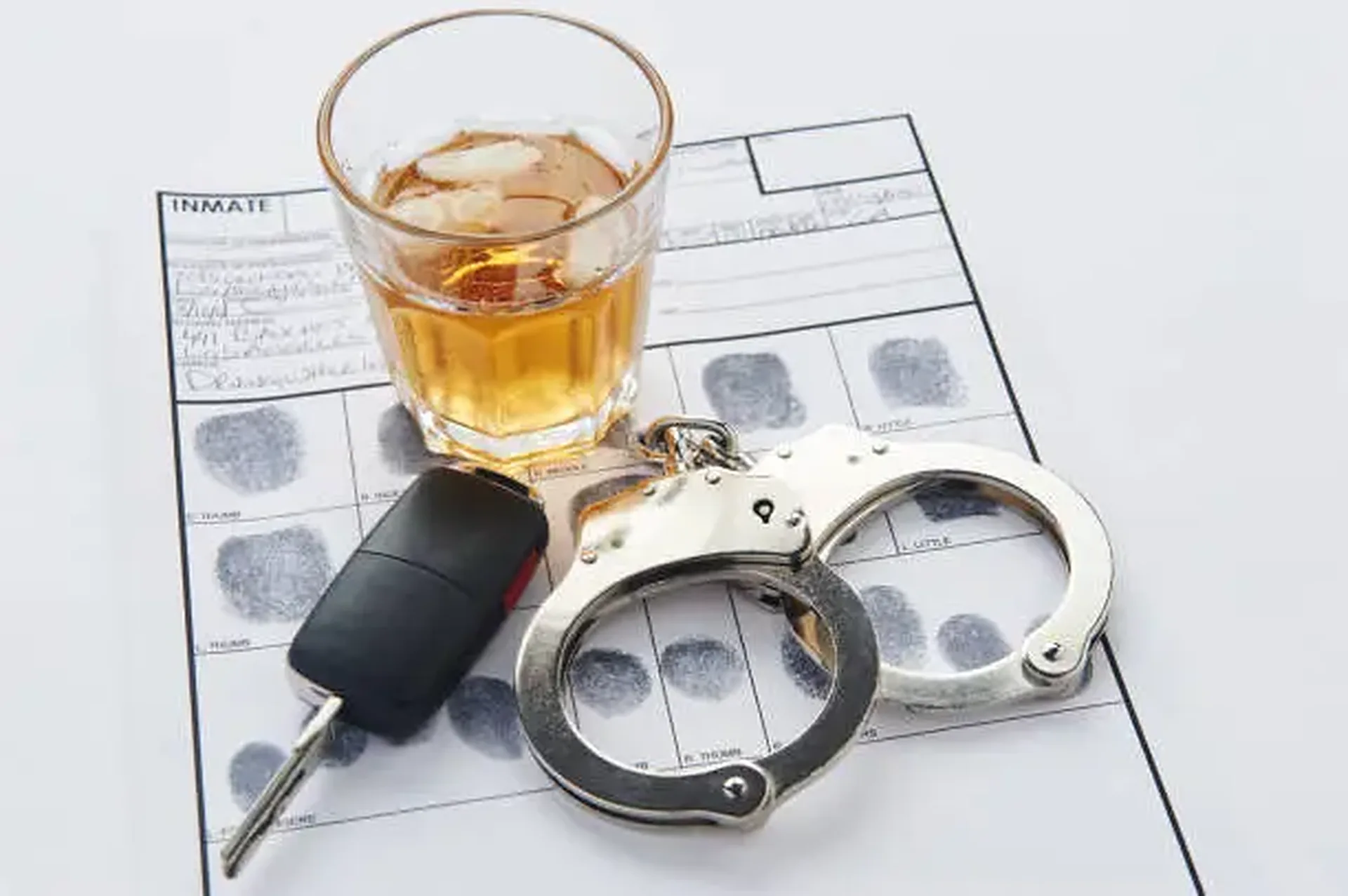 Alkohol, kluczyki i kajdanki na karcie daktyloskopijnej
